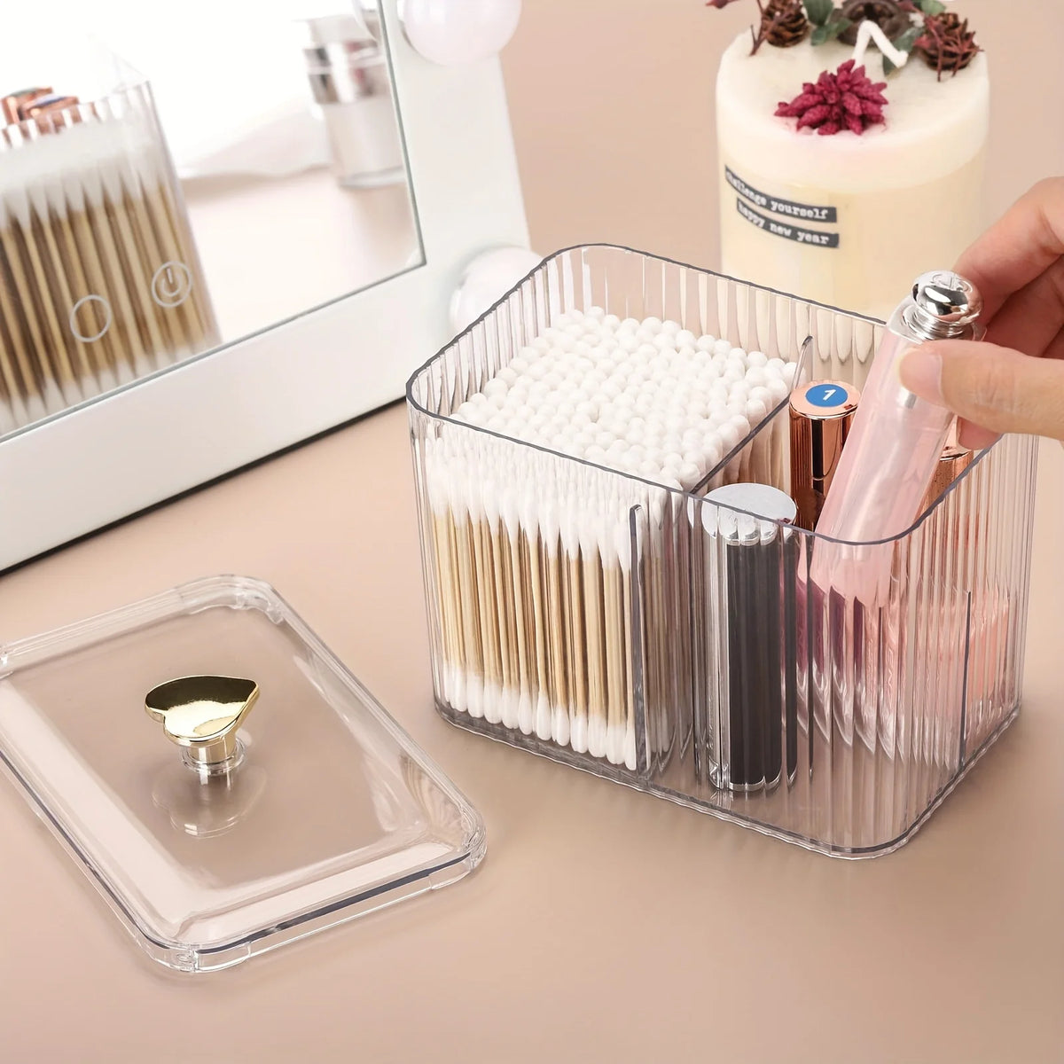 A clear plastic organizer jar holds various cosmetic items like cotton swabs and makeup brushes.