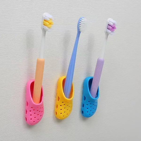 A collection of colorful plastic toothbrushes mounted on an adhesive wall holder.