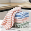 A stack of thickened coral velvet cleaning cloths in various shades of pink, blue, and green.