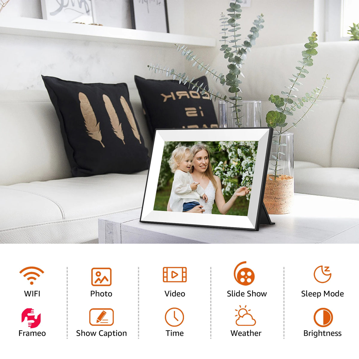 A digital photo frame displaying a smiling woman and child on a white surface with decorative greenery.