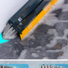 A close-up view of a yellow and black floor scrubbing brush being used to clean a dark, wet floor surface.