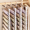 A rack of folded pants hanging on a multi-layer hanger with non-slip clips.