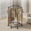 A black rotating hexagon clothes rack with wooden hangers is shown on a light carpet.