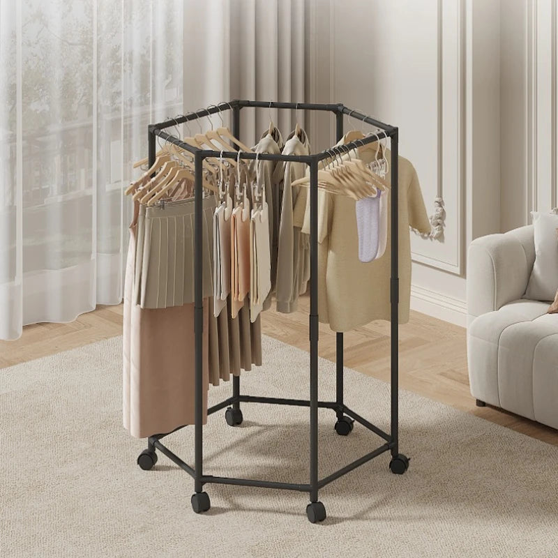 A black rotating hexagon clothes rack with wooden hangers is shown on a light carpet.