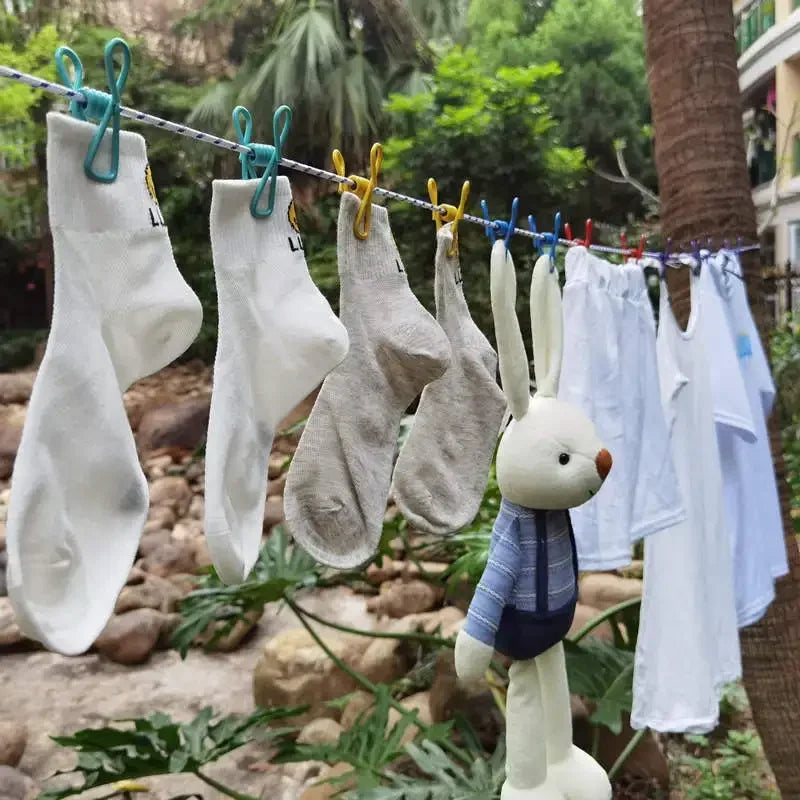 A clothesline strung with white and gray garments, including a rabbit-shaped hanger.