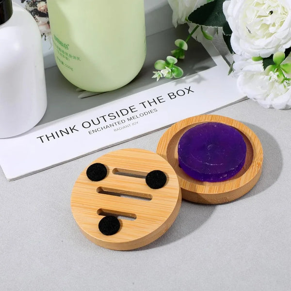 A natural wooden soap dish set featuring a round wooden block with cutouts and a purple soap bar.