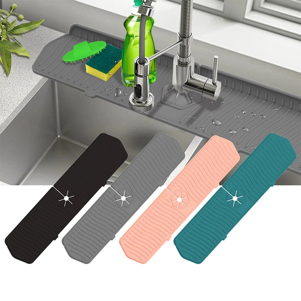 A set of four silicone kitchen sink drain mats in black, gray, pink, and teal are displayed on a metal tray.