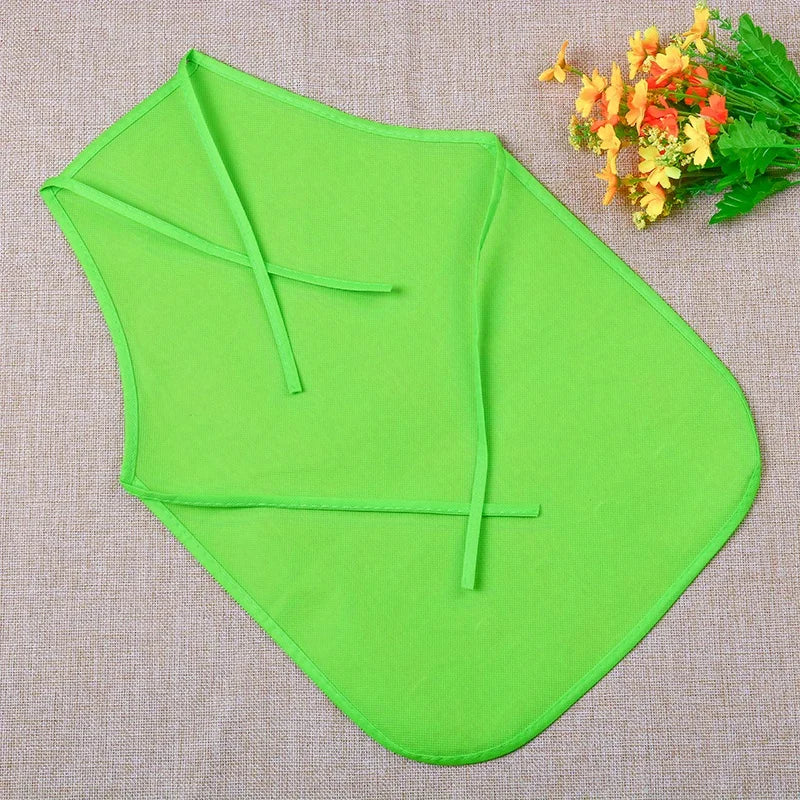 A bright lime green non-woven craft apron folded and displayed on a beige fabric with orange flowers.