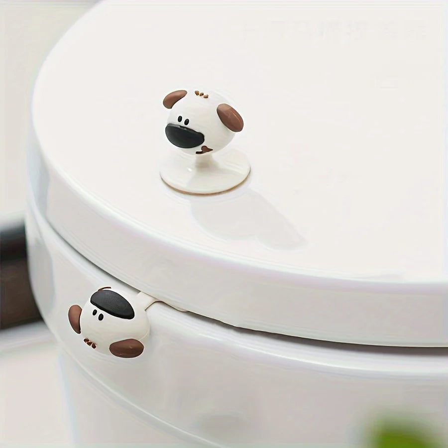 A white cartoon dog-shaped toilet seat lifter handle is visible on a white toilet bowl.