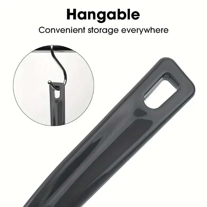 A close-up view of a black, hangable crevice cleaning brush with a flexible handle and a loop for storage.