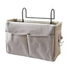 A light gray fabric storage box with two pockets and a black hanging rack.