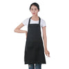 A woman wearing a black oil-proof cooking apron over a white shirt.