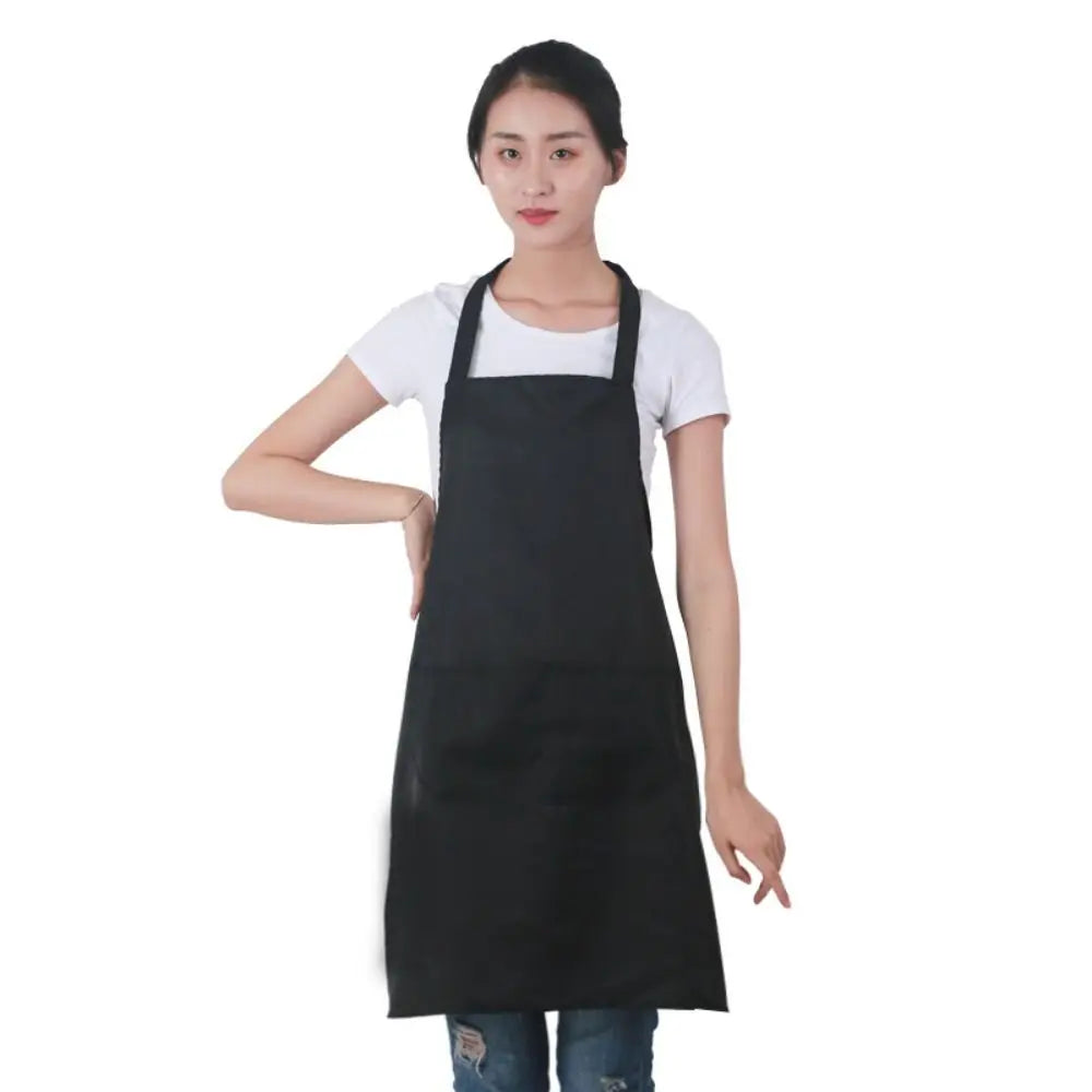 A woman wearing a black oil-proof cooking apron over a white shirt.