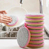 A stack of pink and gray double-sided kitchen cleaning towels and dish sponges being rinsed under running water.