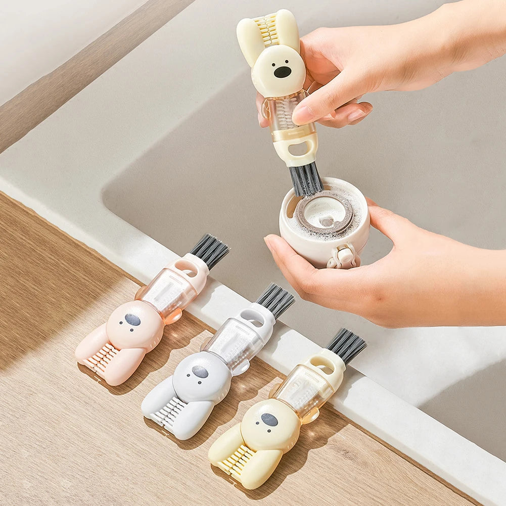 A hand is holding a set of four portable cleaning brushes for cups and bottles on a wooden surface.