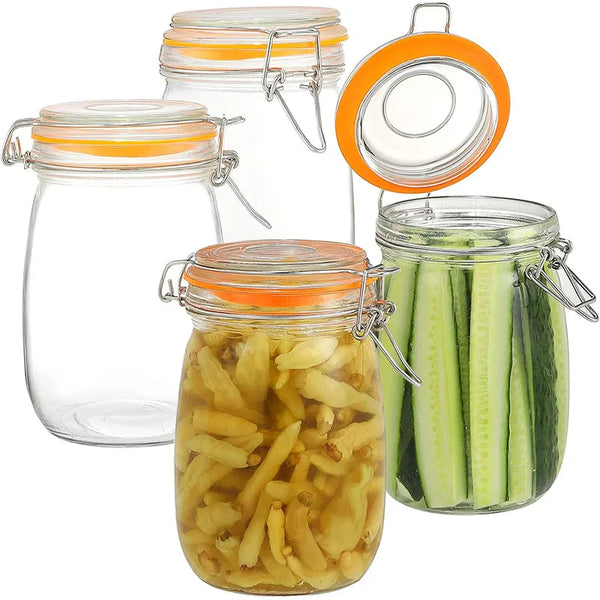 A set of large leakproof glass mason jars with orange lids and metal clasps, some filled with pickled cucumbers.