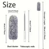 A gray electric duster shown next to its telescopic rods and a measurement scale.