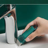 Eine Hand benutzt einen türkisen Zitronensäure-Radiergummi an einem Edelstahlwasserhahn, der bereit für die Benutzung ist.