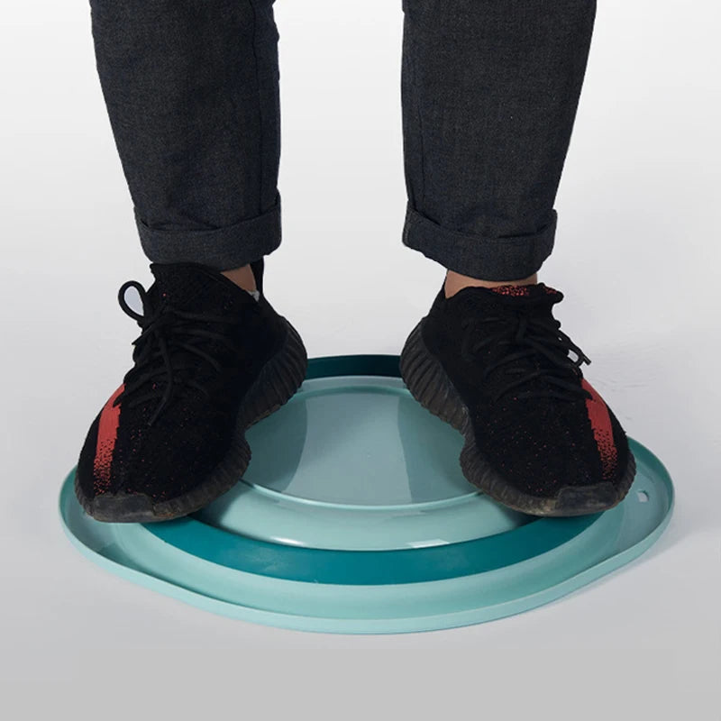 Un par de piernas vistiendo pantalones y botas negras, de pie sobre un lavabo azul claro.