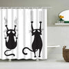 A black cartoon cat with wispy whiskers and a long tail is printed on a white shower curtain.