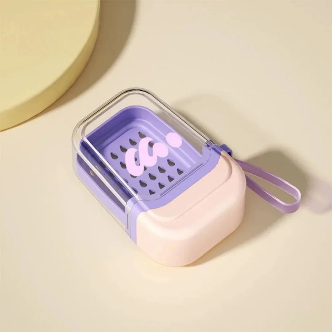 A purple and pink leakproof travel container with a silicone strap is shown on a light background.