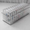 A clear plastic jewelry organizer box filled with various rings and bracelets.