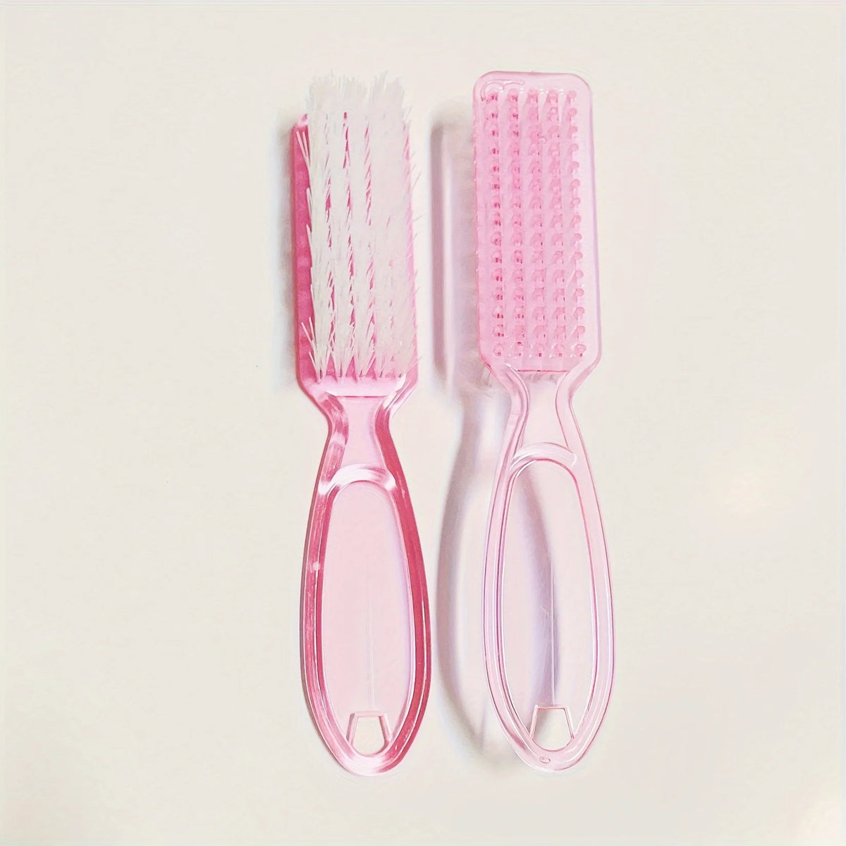 A set of pink multi-purpose brushes for nail art and dust cleaning, including a flat brush and a round brush.