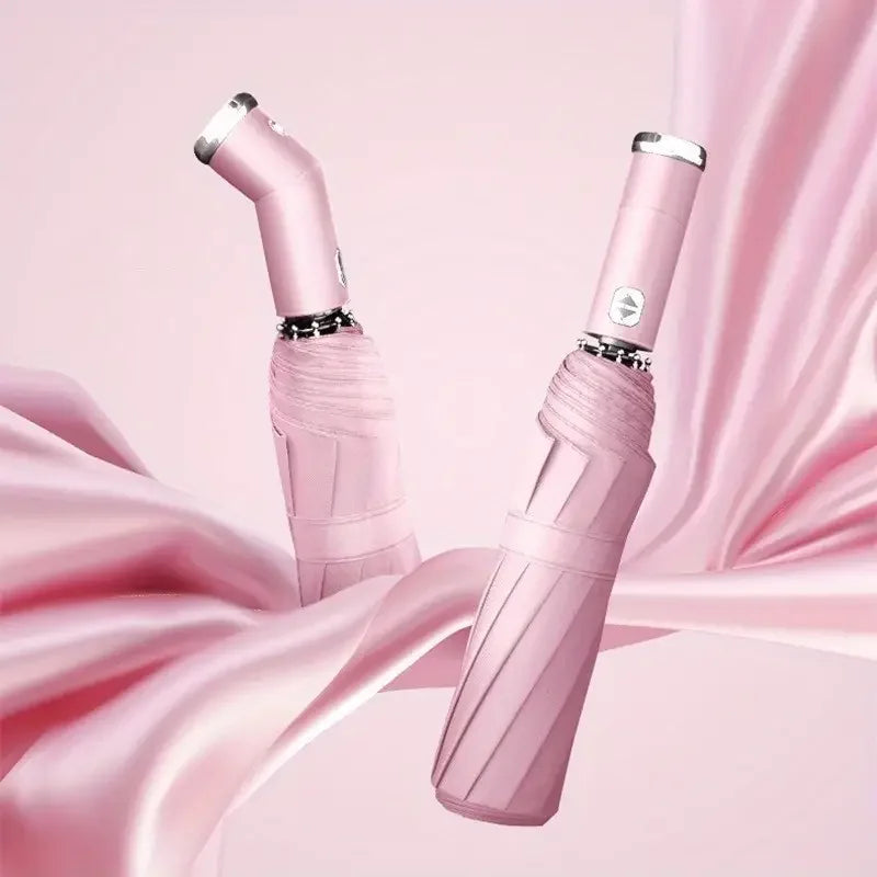 A pink heavy-duty automatic folding umbrella with an LED flashlight is shown against a flowing pink fabric background.
