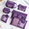 A set of six purple mesh storage bags containing various small items like earbuds and accessories.