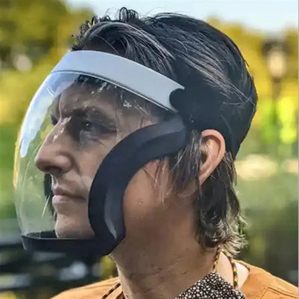 A man wearing a full face anti-splash protective goggles with a clear visor and black frame outdoors.