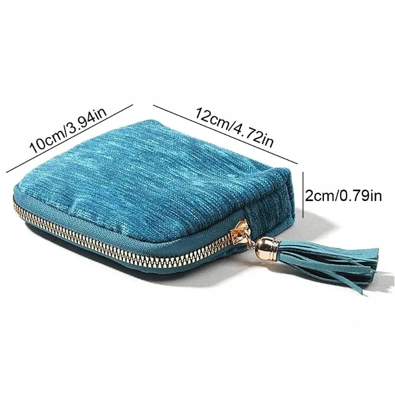 Teal velvet jewelry storage bag with a gold zipper and tassel detail