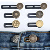 A set of adjustable button extenders in gold and brass colors shown against a denim fabric.