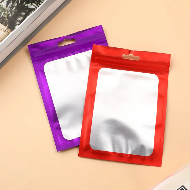 A set of two jewelry display pouches, one purple and one red, lying on a light background.