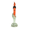 A skeleton hand sculpture holding an orange and black LED candle.
