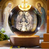A glass crystal ball displaying a religious figure, set on a wooden base with background images of saints.