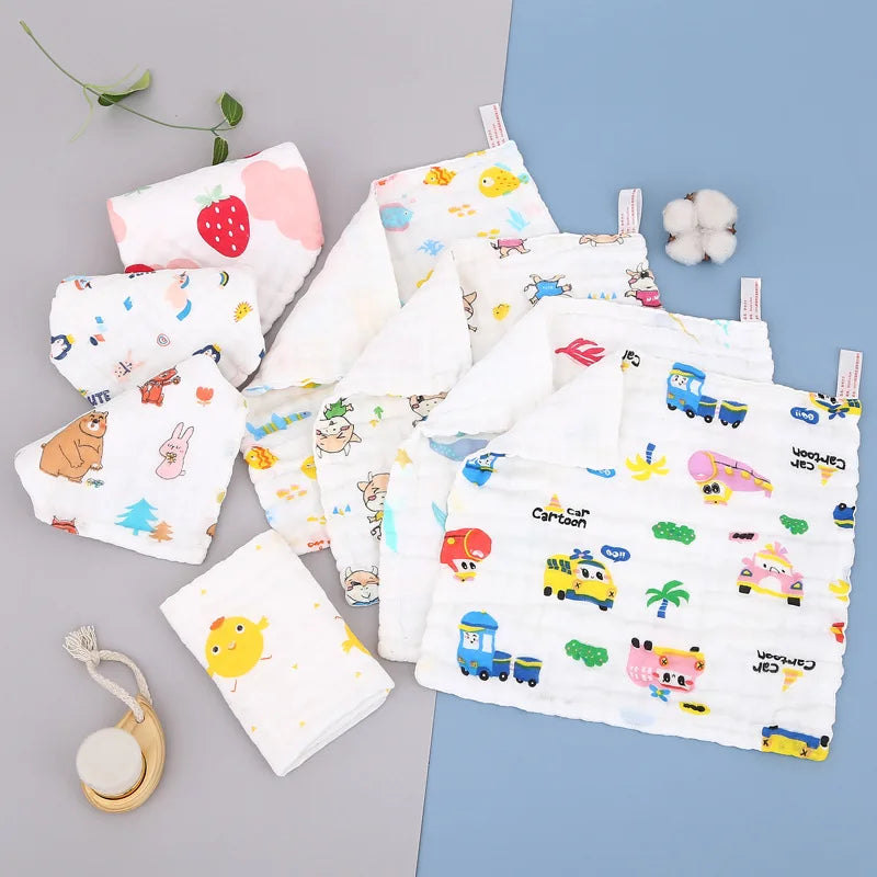 Ein Set aus zwei natürlichen Baumwoll-Muslin-Waschlappen mit verschiedenen niedlichen Cartoon-Figuren und Früchten auf hellem