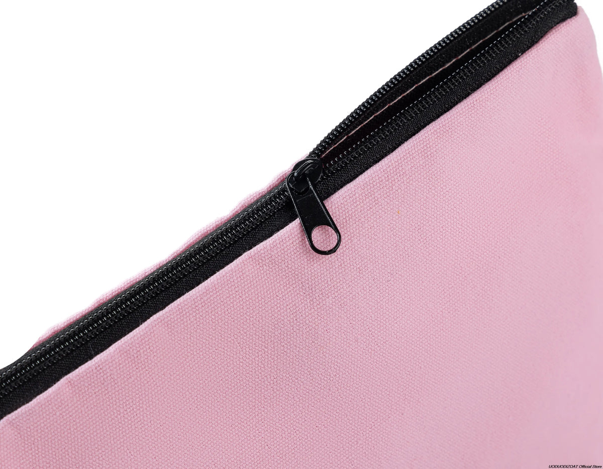 Pink zipper bag showing the black zipper detail on a fabric surface.