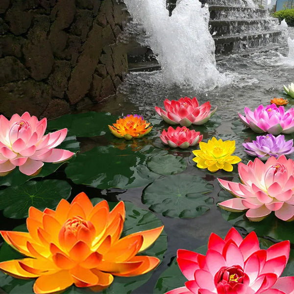 A collection of artificial lotus flowers in various shades of pink, orange, and yellow floating on water.