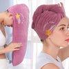 A woman is holding a pink towel with a rainbow star design, demonstrating the soft absorbent hair towel.