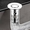 A close-up view of a shiny brass sink drain strainer with a removable metal filter being used to drain water.