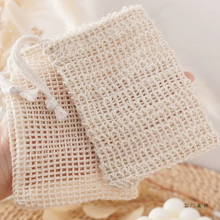 Beige handgemachte Sisas-Seife-Pouch mit getrockneten Blumen im Hintergrund