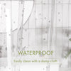 Close-up of a clear shower curtain with water droplets on the surface, demonstrating its waterproof quality.