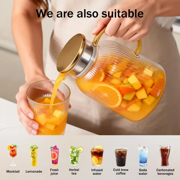 A hand pours orange juice from a glass pitcher into a drinking glass, demonstrating the suitability of the high borosilicate 