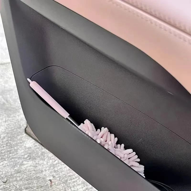 A pink extendable microfiber duster brush is shown inside a dark storage case.