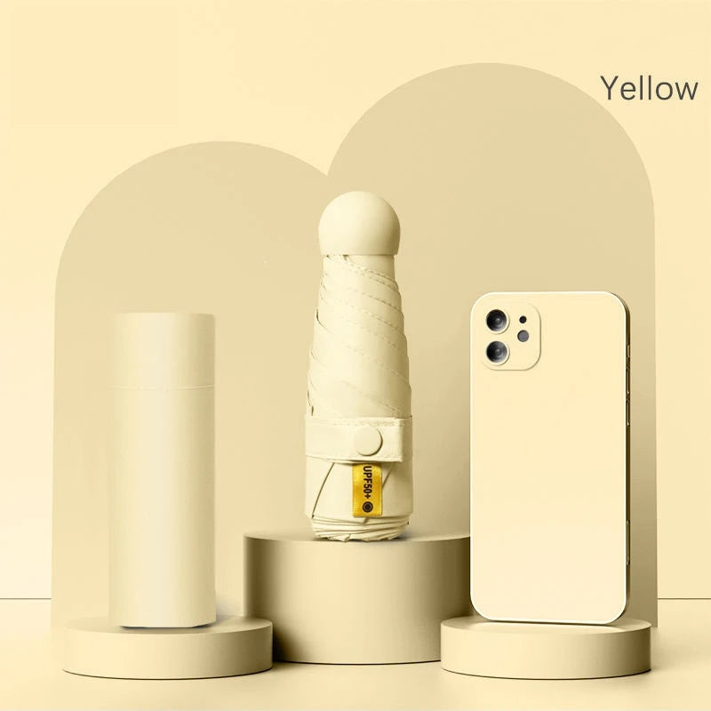A beige folding UV protection umbrella next to a white smartphone on a light background.