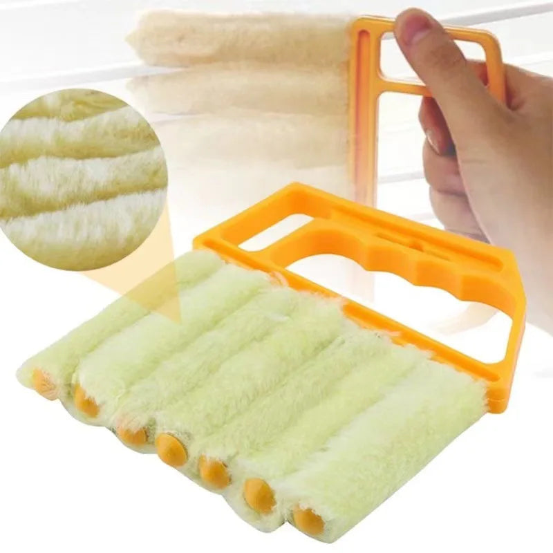 An orange multi-functional cleaning brush with soft green bristles is shown being used to clean blinds or crevices.