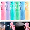 A row of five colorful refillable mist spray bottles in pink, purple, teal, green, and blue.