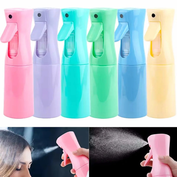 A row of five colorful refillable mist spray bottles in pink, purple, teal, green, and blue.