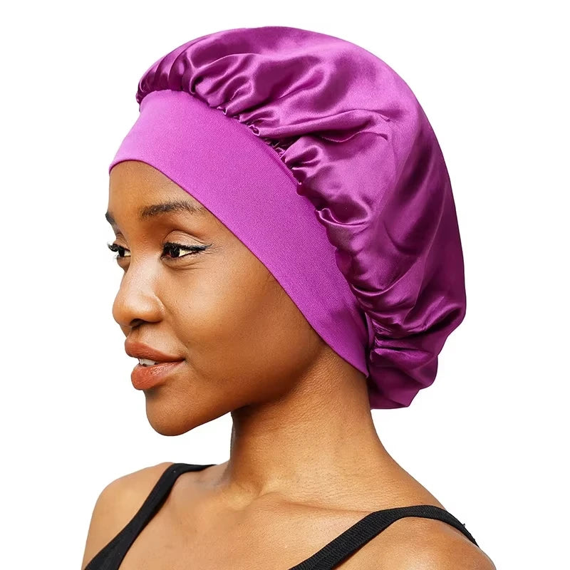 A woman wearing a vibrant purple satin wide-brim sleeping bonnet.