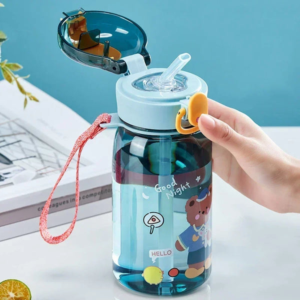 A clear blue sippy cup with a lid and straw featuring a cute cartoon bear design for children.